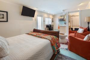 a bedroom with a bed and a couch and a chair at Studio Blue in Key West