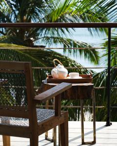 a tea pot sitting on a table next to a chair at Cardamon Hotel Nilaveli in Nilaveli