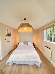 a bedroom with a large white bed in a room at Lumin Lodge -Calm, cosy space near Norwich Airport in Horsham Saint Faith