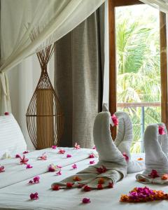 Una cama con toallas y flores encima. en Cardamon Hotel Nilaveli, en Nilaveli