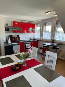 uma cozinha com armários vermelhos, uma mesa e cadeiras em Diamanthaus 1 Koblenz em Koblenz