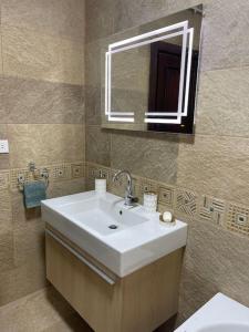 a bathroom with a sink and a mirror at New Maadi Apartment Families Only in Cairo