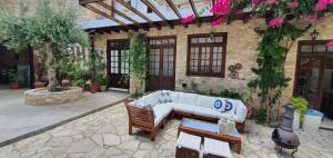 a patio with a white couch in front of a building at Bougainvillea House Lefkara in Pano Lefkara