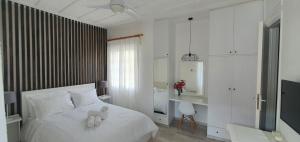 sypialnia z białym łóżkiem z dwoma misiami w obiekcie Bougainvillea House Lefkara w mieście Lefkara