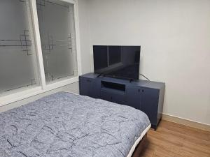 a bedroom with a bed and a flat screen tv at Byeongjeom-yeok Stay 