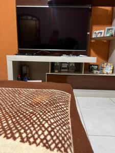 a flat screen tv sitting on a white entertainment center at Sobrado lindo em Itú a 5 minutos do Centro ! in Itu
