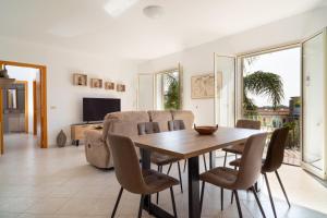 a dining room with a table and chairs at Costa Holiday Home in Mascali