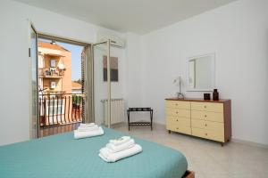 a bedroom with a bed and a dresser and a mirror at Costa Holiday Home in Mascali