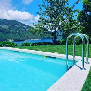 a swimming pool with a view of a lake at Casa do Penedo - Quinta de Fundevilla in Geres