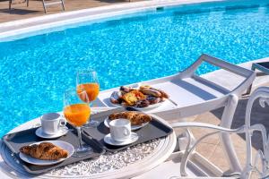 a table with food and drinks next to a swimming pool at Villa Luciano "Spirit of the Canaries" in Tías