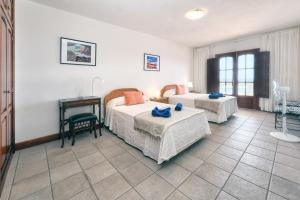 a hotel room with two beds and a desk at Villa Luciano "Spirit of the Canaries" in Tías