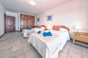 a bedroom with two beds with blue bows on them at Villa Luciano "Spirit of the Canaries" in Tías