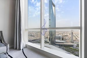 a room with a large window with a view of a city at Walaa Homes Luxury 2BR at DAMAC Esclusiva Tower Riyadh-3104 in Riyadh