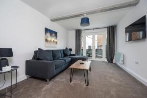 3 King Charles Court, Sudbury في سودبيري: غرفة معيشة مع أريكة زرقاء وطاولة