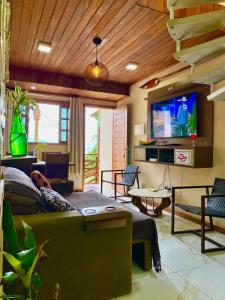 Il comprend un salon doté d'un canapé et d'une télévision à écran plat. dans l'établissement Visual do Abraão, à Angra dos Reis