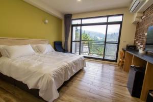 a bedroom with a large bed and a large window at 晨煦行旅 in Lugu