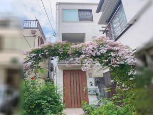 - un bâtiment avec une porte fleurie dans l'établissement 新規OPEN8割！1棟貸切・10名可能！秋葉原まで13分、新宿まで32分／スカイツリー近く, à Tokyo