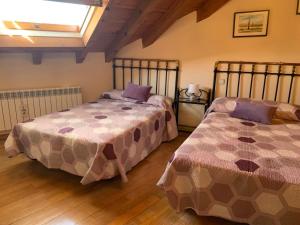 1 dormitorio con 2 camas y ventana en Rincón de Ayllon, en Ayllón