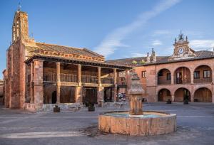 een oud gebouw met een fontein midden op een binnenplaats bij Rincón de Ayllon in Ayllón