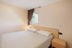 a bedroom with a white bed and a window at Al Baitin Trepalle in Livigno