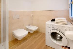 a bathroom with a washing machine and a toilet at Al Baitin Trepalle in Livigno