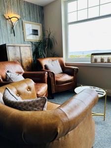 a living room with a couch and chairs and a window at Beach House Hotel in Seahouses