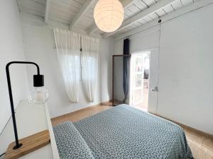1 dormitorio con 1 cama en una habitación con ventana en La Milagrosa Surf House & CoWork, en Lajares