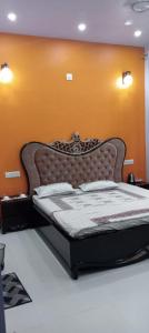 a bed in a bedroom with an orange wall at Kailash Haveli in Bikaner