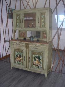 a wooden cabinet with paintings on it in a room at la ruée vers l'art 