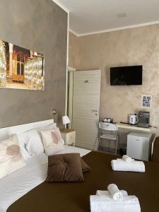 una camera con letto e scrivania con TV di Joy Naples a Napoli