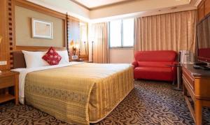 台北的住宿－麗雅精品旅館，酒店客房设有一张大床和一张红色沙发。