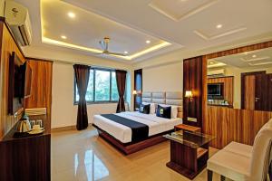 una camera d'albergo con letto e soggiorno di OYO Palette - The Grand Aryans Hotel a Calcutta