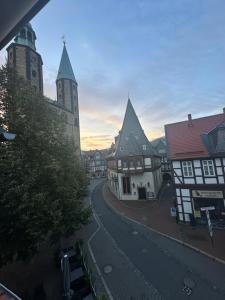 una calle de la ciudad con edificios y una torre del reloj en Goslar LIVING 1 - direkt am Weihnachtsmarkt, en Goslar