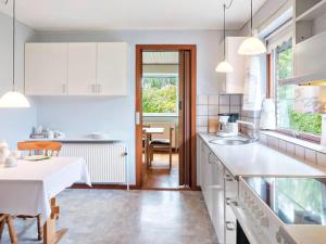 a kitchen with white cabinets and a table in it at Single Room in Rødby