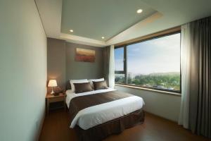 Кровать или кровати в номере Benikea Jungmun Hotel