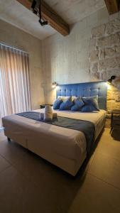 a large bed in a room with a brick wall at Sea Holly Gozo in Nadur