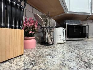 a kitchen with a counter top with a microwave and flowers at Private Upgraded Unit Near Hof in Canton