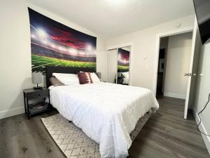a bedroom with a large white bed with a large painting on the wall at Private Upgraded Unit Near Hof in Canton