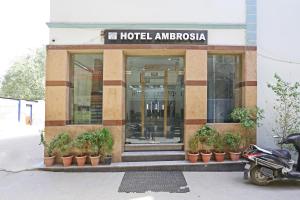 uma entrada do hotel com uma scooter estacionada em frente em Hotel Ambrosia - A Boutique Hotel em Nova Deli