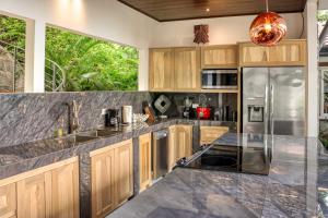 a kitchen with wooden cabinets and stainless steel appliances at Terrazas de Ballena in Uvita