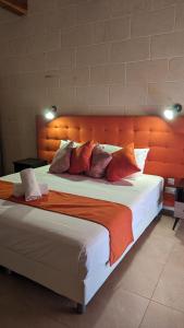 a large bed with an orange headboard in a room at Sea Holly Gozo in Nadur