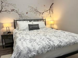 a bed with a black and white comforter and two lamps at Downtown Cleveland -modern First Floor Unit in Cleveland