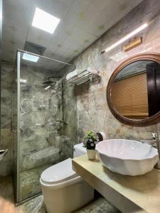 a bathroom with a sink and a toilet and a mirror at Sapa Adam Hotel in Lao Cai