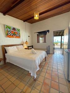- une chambre avec un grand lit blanc dans l'établissement Pousada Casa Feliz Maxaranguape, à Maxaranguape