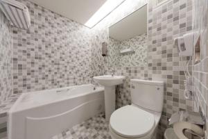 a bathroom with a white toilet and a sink at Harbor View Hotel in Keelung