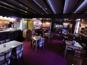 un restaurante con mesas y sillas y un bar en Ye Olde Cheshire Cheese Inn en Castleton