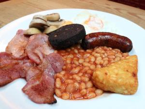 a plate of breakfast food with beans and bacon at Ye Olde Cheshire Cheese Inn in Castleton