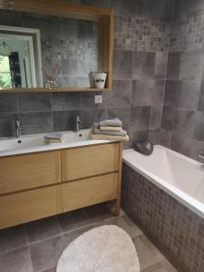 ein Badezimmer mit einem Waschbecken und einer Badewanne in der Unterkunft LA PAUSE in Surville
