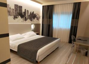 a hotel room with a bed and a window at The Sydney Hotel in Bologna