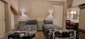 a bedroom with two beds and a table in it at Il Mulino B&B in Rivara